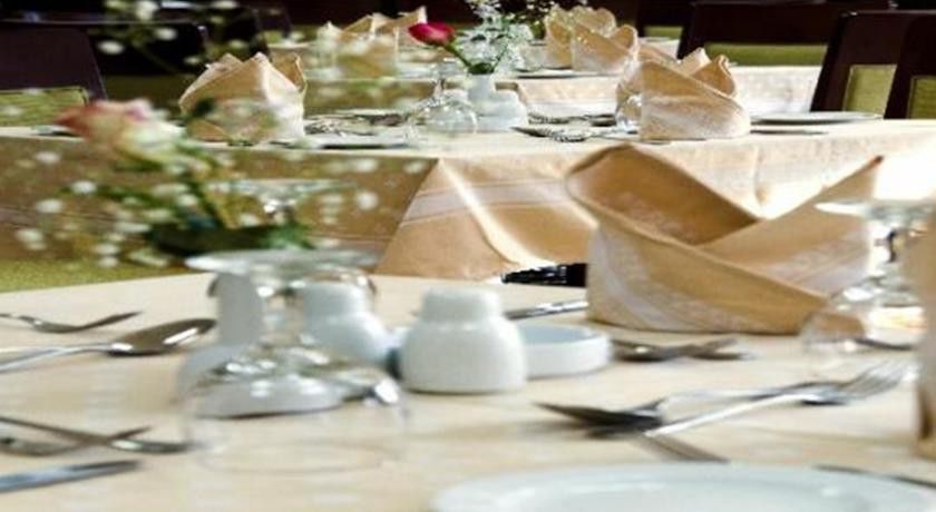 فندق مكارم أم القرى مكة المظهر الخارجي الصورة The photo shows a beautifully set dining table. The table is adorned with a cream-colored tablecloth and features neatly arranged dinnerware, including plates, cutlery, and glassware. Folded napkins are elegantly placed, and there are small flower ar