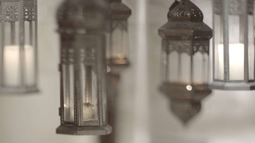 فندق مكارم أم القرى مكة وسائل الراحة الصورة The photo shows a collection of decorative lanterns hanging from a surface. The lanterns are made of metal with intricate designs, and they have glass panes that allow light to shine through. The overall atmosphere appears warm and inviting, likely s