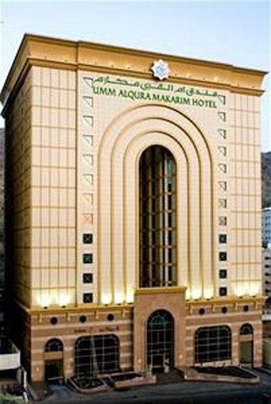 فندق مكارم أم القرى مكة المظهر الخارجي الصورة The photo shows a building that appears to be a hotel, characterized by a distinctive architectural style. The façade features an arched entrance with prominent vertical lines, giving it a modern yet elegant look. The exterior is a light color, possi
